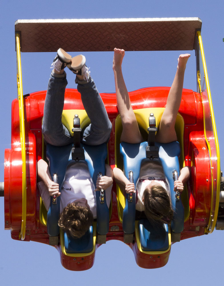 Two people hang upside down in a roller coaster